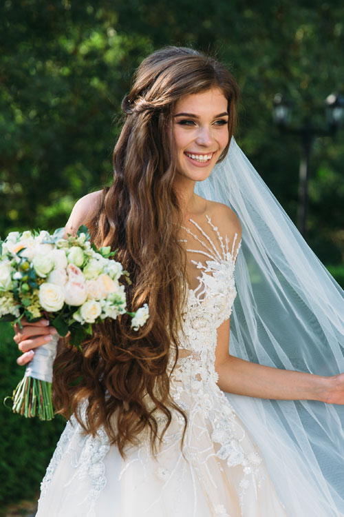 Bride walking holding veil